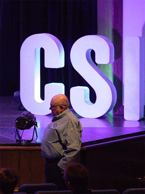 Dr. Tim in front of large CSI letters