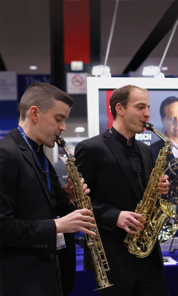 Three men demoing instruments at a tradeshow