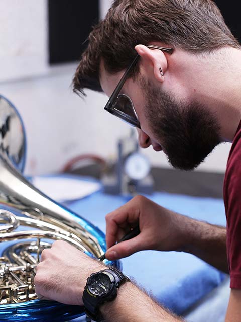 man working on an instrument assembly