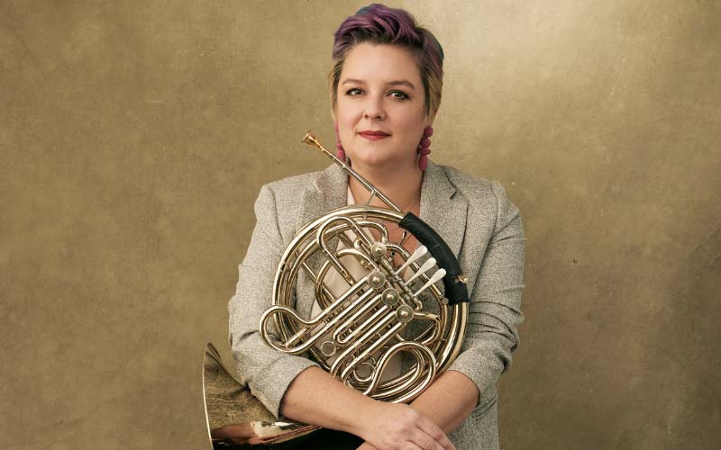 Laura Brenes sitting with a horn