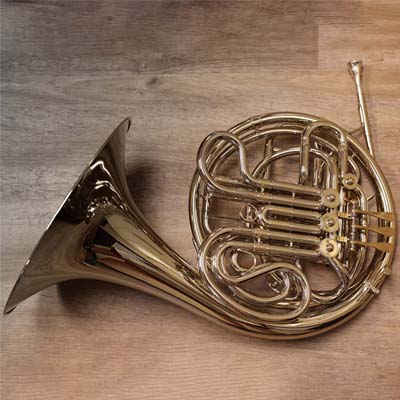 A french horn atop a wooden table