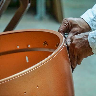 Employee manufacturing a timpani
