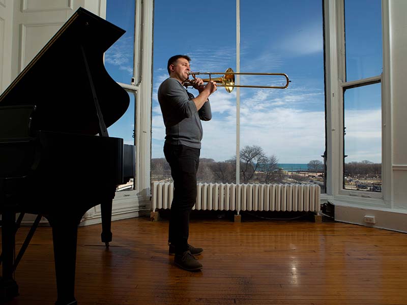 An artist casually playing in front of the studio window